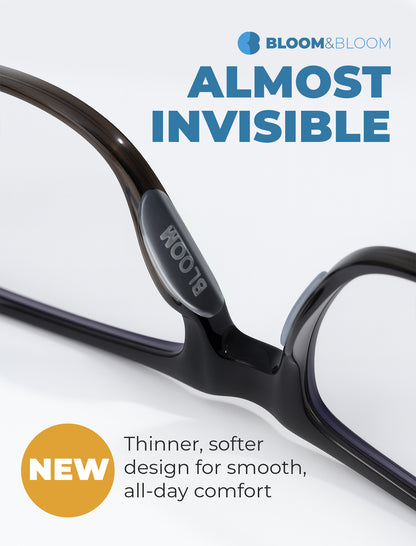 Clear silicone nose pads displayed next to eyeglass frame and adhesive liner, showing individual pad size and curved ergonomic shape